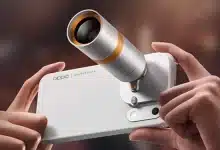 Hands holding the OPPO Hasselblad teleconverter kit attached to the phone for extreme optical zoom